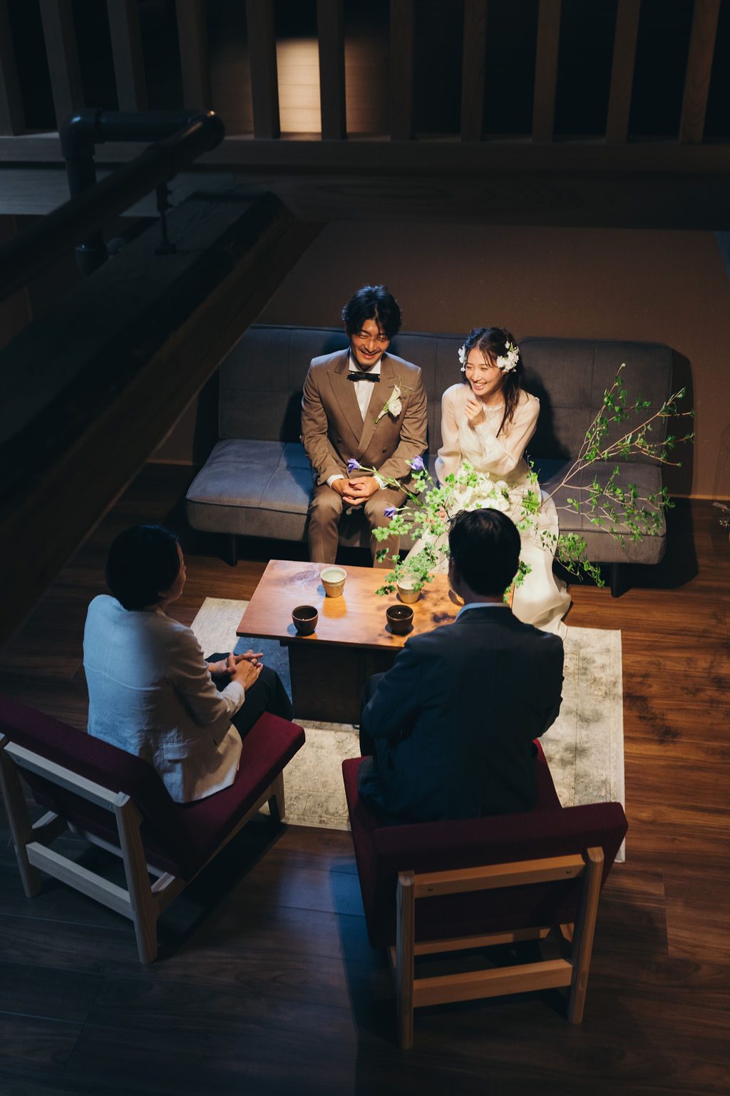 古民家のラウンジで家族と寛ぐ新郎新婦、低いテーブルを囲む団欒